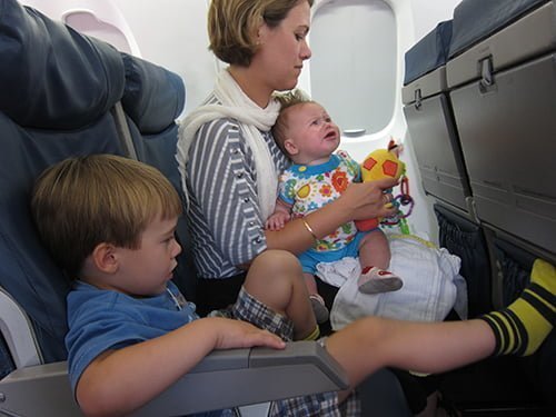 Acomodando a los ni&ntilde;os en el avi&oacute;n