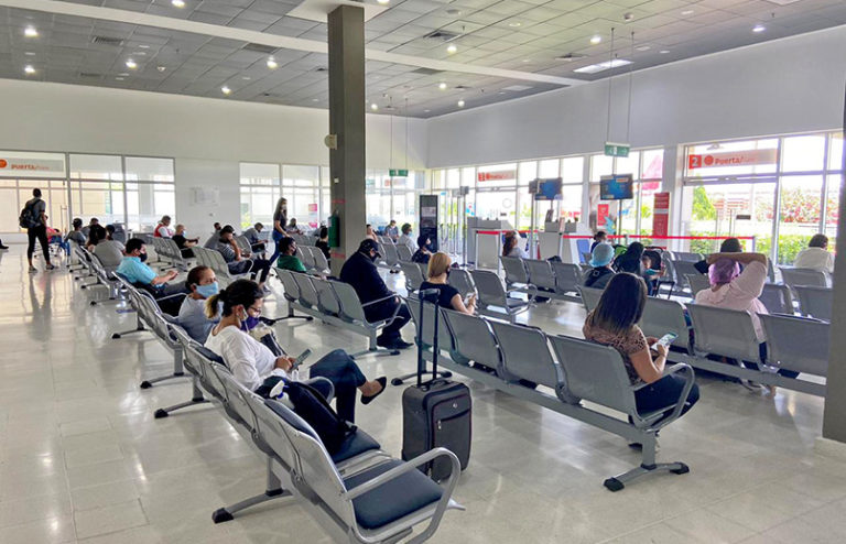 Pasajeros en sala de espera de un aeropuerto.