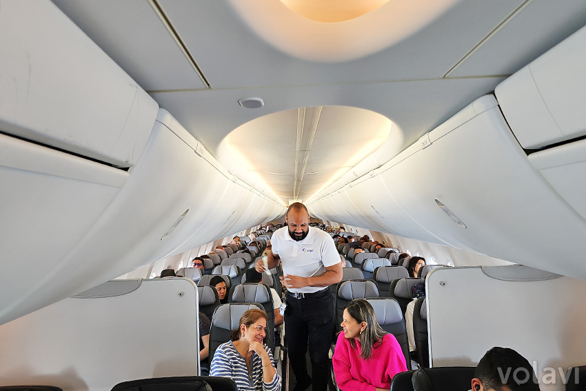 Cabina del Boeing 737 MAX 8 de Arajet con el sistema de iluminación en cabina encendido y vista de los compartimentos de equipaje más grandes.