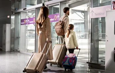 Familia de pasajeros viajando en un aeropuerto.