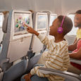 Niño disfruta del sistema de entretenimiento a bordo de un avión de Emirates.