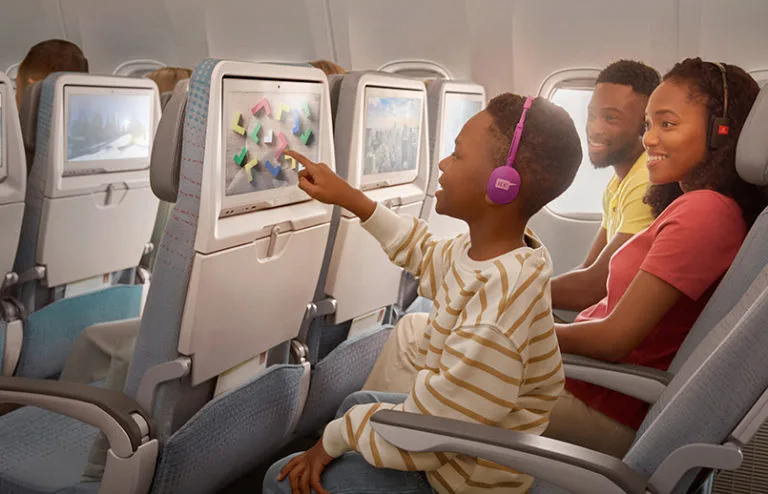 Niño disfruta del sistema de entretenimiento a bordo de un avión de Emirates.