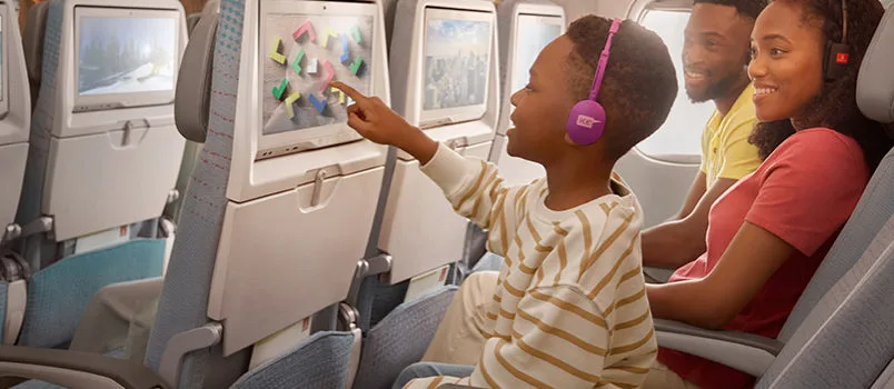 Niño disfruta del sistema de entretenimiento a bordo de un avión de Emirates.