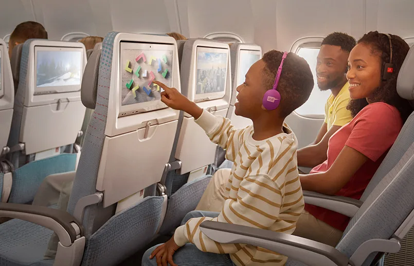 Niño disfruta del sistema de entretenimiento a bordo de un avión de Emirates.