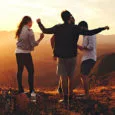 Grupo de amigos disfruta del atardecer durante un viaje en grupo.