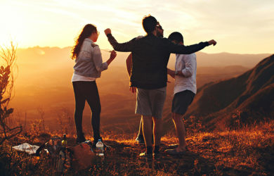 Grupo de amigos disfruta del atardecer durante un viaje en grupo.