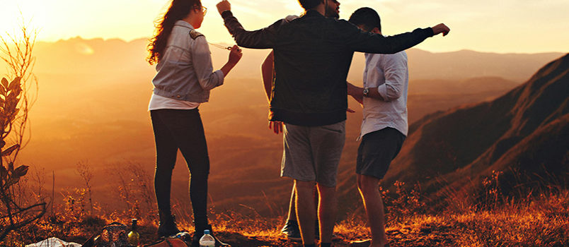 Grupo de amigos disfruta del atardecer durante un viaje en grupo.