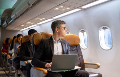 Pasajero en un avión haciendo uso de la tecnología.