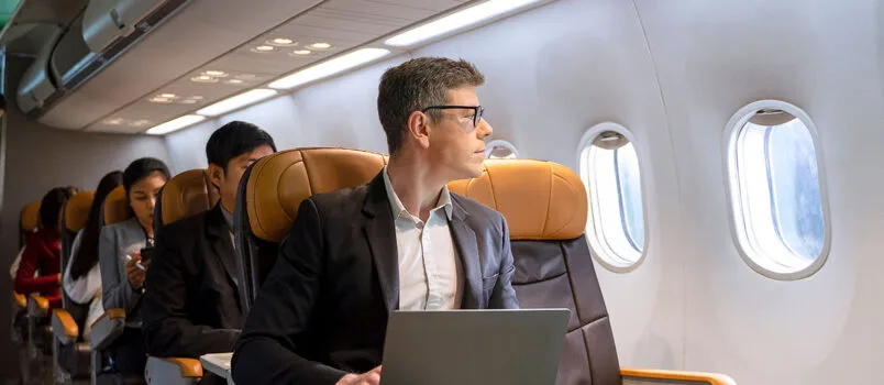 Pasajero en un avión haciendo uso de la tecnología.